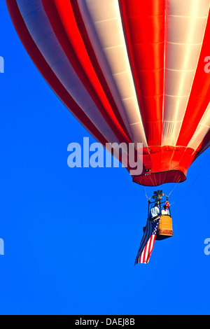 Closeup on red and white hot air balloon flying American flag against blue sky at Spirit of Boise Balloon Classic in 2011 Stock Photo