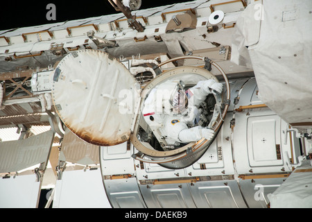 NASA astronaut Chris Cassidy emerges from the Quest airlock during a spacewalk as work continues on the International Space Station July 9, 2013 in Earth orbit. During the six-hour, seven-minute spacewalk, Cassidy and Parmitano prepared the space station for a new Russian module and performed additional installations on the stations backbone. Stock Photo