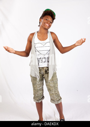 Black woman standing and smiling at the camera with a friendly, happy smile her hands raised in an "I don't know" look Stock Photo