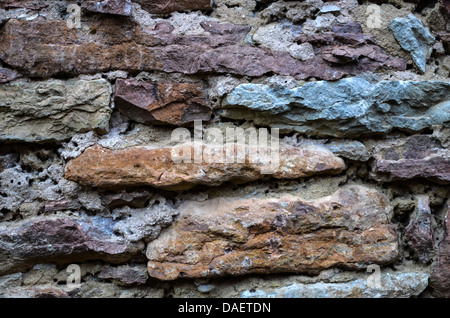 Old weathered brickwall of limestones in different colours Stock Photo