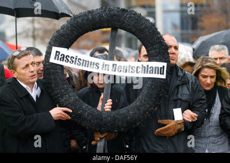 Protesters stand around a mourning wreath for racism in front of the Reichstag in Berlin, Germany, 03 December 2011. The Turkish Association of Berlin-Brandenburg has organised a motorcade to protest the spate of murders by the terrorist group 'Nationalsozialistischer Untergrund' (NSU). Photo: FLORIAN SCHUH Stock Photo