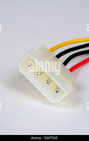 Four pin peripheral power connector from PSU in tower PC against a plain background. Stock Photo