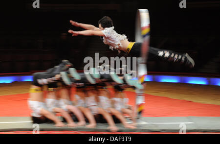 The 18-year-old Chinese artistic performer Qu Hao jumps through a hoop at a height of 2,55 meters during a press rehearsal at the Circus Krone in Munich, Germany, 15 Feburary 2011. In a master show, 14 world class artists perform high jumps through hoops. According to the circus, the world's highest jump is at 2,55. Photo: Marc Mueller Stock Photo