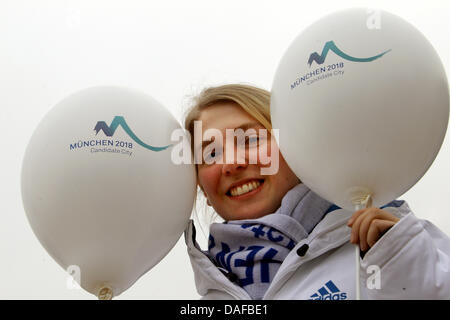 A woman holds up balloons advocating Munich as Olympic City 2018 at the Alpine Skiing World Cup 2011 in Garmisch-Partenkirchen, Germany, 16 February 2011. Photo: Stephan Jansen Stock Photo