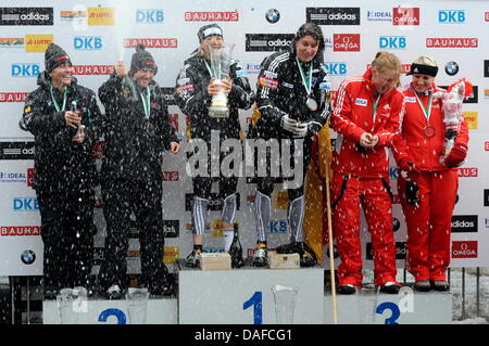 Die us-amerikanischen Bobpilotinnen Valerie Fleming (l-r) und Shauna Rohbock, die deutschen Bobpilotinnen Cathleen Martini und Romy Logsch  sowie die Die kanadischen Bobpilotinnen Heather Moyse und Kaillie Humphries stehen am Samstag (19.02.2011) bei der Bob-Weltmeisterschaft auf der Kunsteisbahn am Königssee (Oberbayern) bei der Siegerehrung zusammen und spritzen Champagner. Marti Stock Photo