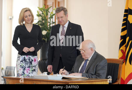 German President Christian Wulff (C) and his wife Bettina (L) watch former Soviet leader Mikhail Gorbachev (R) signing the Golden Book of Bellevue Palace in Berlin, Germany, 24 February 2011. Gorbachev's policy rang in the end to Cold War and was recognised with the Nobel Peace Prize in 1990. He celebrates his 80th birthday on 02 March 2011. Photo: JOERG CARSTENSEN Stock Photo