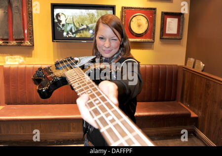 Austrian rock singer Christina Stuermer poses with a bass guitar which Stuermer's band has signed, in the Hard Rock Cafe in Munich, Germany, 25 February 2011. Stuermer donated some memorabila on the occasion of the Munich Hard Rock Cafe's ninth anniversary. Photo. Felix Hoerhager Stock Photo