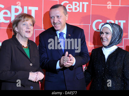 (L to R:) German Chancellor Angela Merkel, Turkish Prime Minister Recep Tayyip Erdogan and his wife Emine attend the opening of information technology trade show CeBIT in Hanover, Germany, 28 February 2011. More than 4,200 companies from 70 countries showcase their latest products at the world's leading computer expo which takes place from 01 to 05 March. Photo: JOCHEN LUEBKE Stock Photo