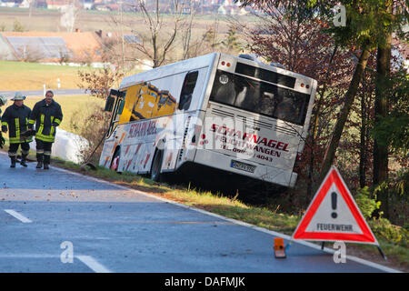 A bus lies in the ditch on a road near Herrieden, Germany, 05 December 2011. Seven children were injured in the school bus accident in the morning. According to the police, the bus straited from the street due to unknown reasons. Photo: DANIEL KARMANN Stock Photo