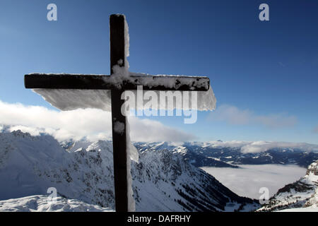The summit cross is covered with frozen ice on the top of the Nebelhorn mountain near Oberstdorf, Germany, 11 December 2011. Due to the lack of snow the winter sports season starts slowly in the Allgaeu region. Only a few ski slopes are open. Photo: KARL-JOSEF HILDENBRAND Stock Photo