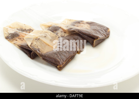 Some removed tea bags on white dish Stock Photo