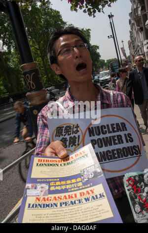 London, UK. 12 July 2013, London.  A Japanese campaigner hands out leaflets as he holds a vigil at the Japanese Embassy in London, protesting against nuclear power. Credit:  Paul Davey/Alamy Live News Stock Photo