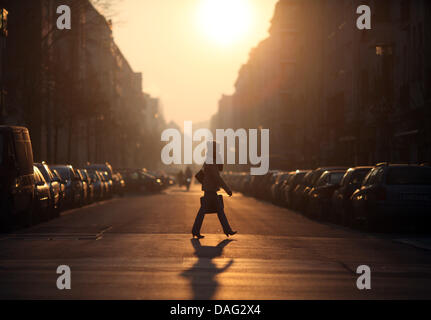 The picture shows a pedestrian crossing a street at sunrise in the area Friedrichshain in Berlin, Germany on 04 March 2011. Photo: Kay Nietfeld Stock Photo