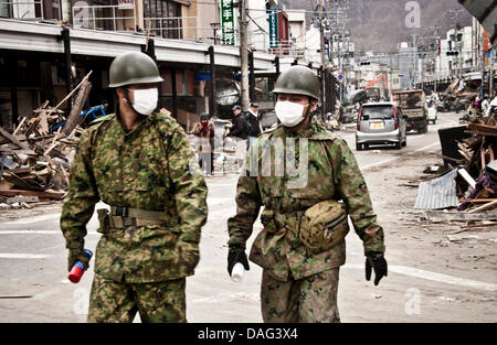 Two members of the Japan Self-Defense Forces wear masks around 100 Kilometers north of the city of Sendaiin on a devastated street in the town of Kamaishi, northeastern Japan, 15 March 2011. The region was hit by a strong earthquake followed by a tsunami on Friday, March 11. Photo: Wojciech P. Onak Stock Photo