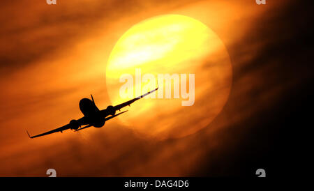 (dpa file) A file picture dated 07 February 2011 shows a plane flying at sunset at Düsseldorf airport in Düsseldorf, Germany. According to the Market Research Institute GdfK-Marktforschung Germans are more inclined to book vacations. After the economic upswing the number of booked vacations until the end of January rose by 18 percent. Photo: Julian Stratenschulte Stock Photo