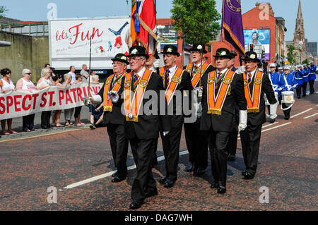 Belfast, Northern Ireland, 12th July 2013 - The annual 12th July parade passes the Roman Catholic St. Patrick's Church and a protest by parishoners. Advertising banner in the background reads 'Lots of Fun' Credit:  Stephen Barnes/Alamy Live News Stock Photo