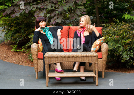 Compsite Image of same model with different hair color sitting on couch - Brevard, North Carolina USA Stock Photo