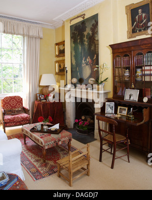 Upholstered ottoman stool in front of fireplace in traditional ...