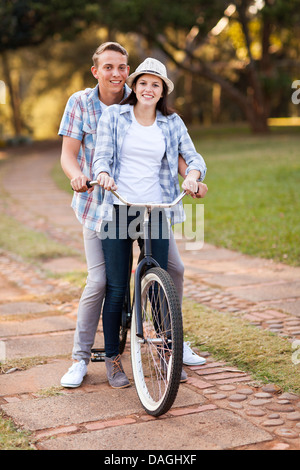 loving teenage couple riding bicycle together outdoors Stock Photo