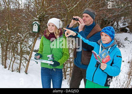 bird watching in the garden in winter, family watching birds, Germany Stock Photo