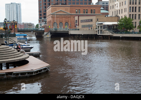 Two women sit by the Milwaukee river in Milwaukee Stock Photo