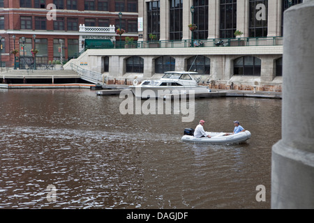 A small boat is seen on the Milwaukee river in Milwaukee Stock Photo