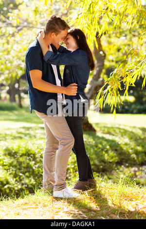 romantic young teenage coupe kissing in forest Stock Photo