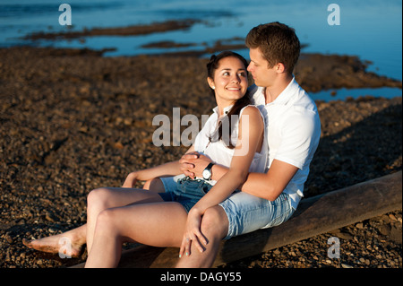Couple in love walks on the banks of the river in denim shorts and a white shirts. Stock Photo