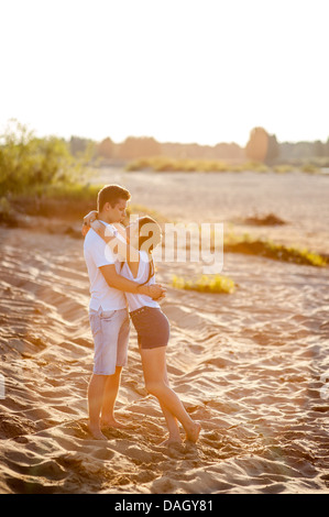 Couple in love walks on the banks of the river in denim shorts and a white shirts. Stock Photo