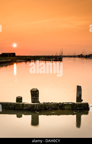 A midsummer sun sets over the river Blyth estuary at Walberswick in Suffolk - England. Stock Photo