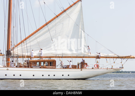 Deck hands rig the sails on the 196-foot sailing yacht Germania Nova as it sails Charleston Harbor June 26, 2013 in Charleston, South Carolina. Stock Photo