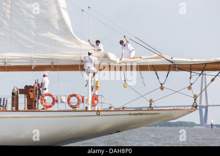 Deck hands rig the sails on the 196-foot sailing yacht Germania Nova as it sails Charleston Harbor June 26, 2013 in Charleston, South Carolina. Stock Photo