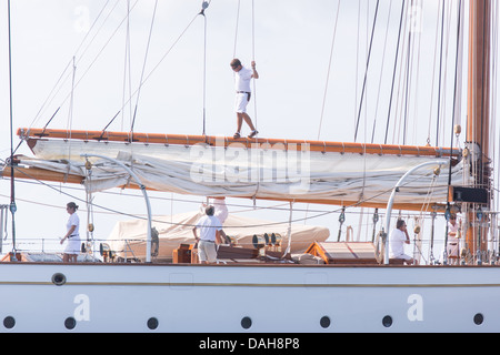 A deck hand rigs the sails on the 196-foot sailing yacht Germania Nova as it sails Charleston Harbor June 26, 2013 in Charleston, South Carolina. Stock Photo