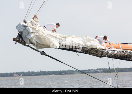 Deck hands rig the sails on the 196-foot sailing yacht Germania Nova as it sails Charleston Harbor June 26, 2013 in Charleston, South Carolina. Stock Photo