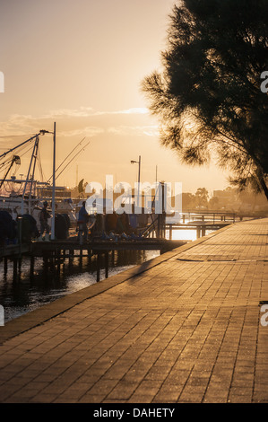 Two men head home after a hard day working at the boat harbour in Lakes Entrance, Victoria. Stock Photo