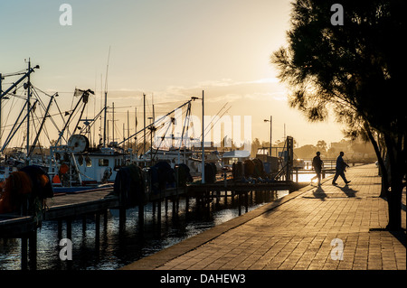 Two men head home after a hard day working at the boat harbour in Lakes Entrance, Victoria. Stock Photo