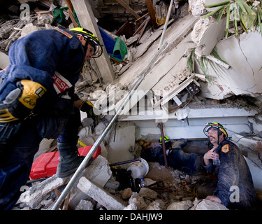 Members of Fairfax County Virginia Urban Search and Rescue team conduct a rescue operation in a collapsed section of the Hotel Montana in the aftermath of a 7.0 magnitude earthquake that killed 220,000 people January 15, 2010 in Port-au-Prince, Haiti. Eight people, including 7 Americans, have been rescued from the rubble of the hotel. Stock Photo