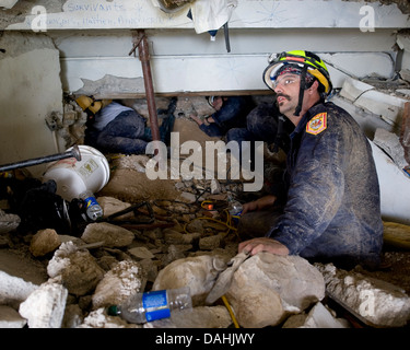 Members of Fairfax County Virginia Urban Search and Rescue team conduct a rescue operation in a collapsed section of the Hotel Montana in the aftermath of a 7.0 magnitude earthquake that killed 220,000 people January 15, 2010 in Port-au-Prince, Haiti. Eight people, including 7 Americans, have been rescued from the rubble of the hotel. Stock Photo