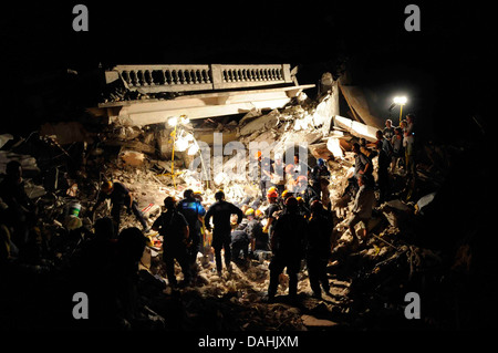 Members of the Los Angeles County Fire Department Search and Rescue Team clear debris at a collapsed building in the aftermath of a 7.0 magnitude earthquake that killed 220,000 people January 17, 2010 in Port-au-Prince, Haiti. Stock Photo