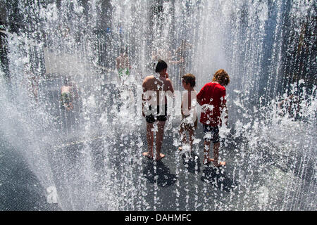London, UK. 14th July, 2013. Children enjoy the cool water of a fountain at the Southbank Centre as temperatures soar into the high twenties in  central London. Credit:  Paul Davey/Alamy Live News Stock Photo
