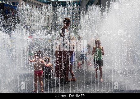 14 July, 2013, London. A woman plays with her child in a fountain at the Southbank centre as thousands of Londoners and tourists enjoy the ongoing hot weather. Credit:  Paul Davey/Alamy Live News Stock Photo