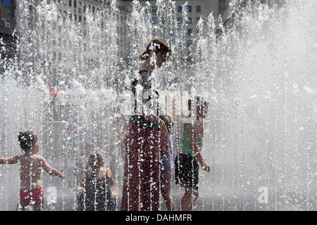 London, UK. 14th July, 2013. A woman plays with her child in a fountain at the Southbank Centre as Londoners and tourists enjoy the ongoing hot, sunny weather. Credit:  Paul Davey/Alamy Live News Stock Photo