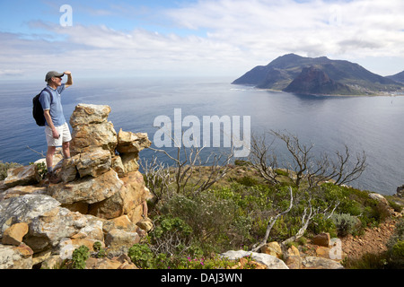 A hiker pauses along the Chapman's Peak section of the Hoerikwaggo Trail, in Table Mountain National Park, South Africa. Stock Photo