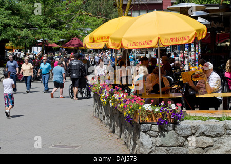 Whistler village with people dining outside on patios at restaurants.  Whistler,  BC, Canada. Stock Photo