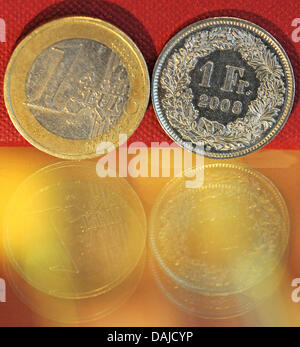 An illustration dated 5 April 2011 of a one-euro coin and one Swiss frank seen in Kreuzlingen, Switzerland. Due to the strong Swiss frank German retailers located at the border area increase their revenue through Swiss customers. Photo: Patrick Seeger Stock Photo