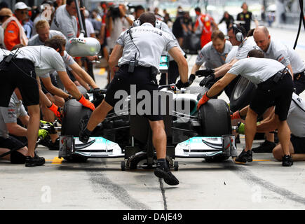 Mechanics exercise pit stops with the car of German Formula One driver Michael Schumacher of Mercedes GP during the first practice session at the Sepang circuit, outside Kuala Lumpur, Malaysia, 08 April 2011.The Formula One Grand Prix of Malaysia will take place on 10 April 2011. Photo: Jens Buettner dpa Stock Photo