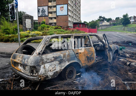 Belfast, Northern Ireland. 15th July 2013 - A burnt out car blocks the road at Mount Vernon following a night of rioting Stock Photo