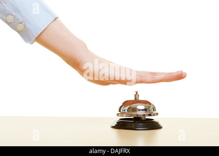 Hands pressing a hotel bell on a reception Stock Photo