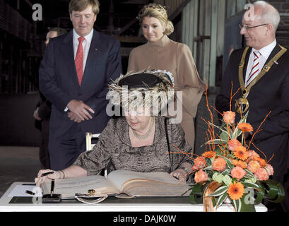 Queen Beatrix of the Netherlands signs the steel book during her visit to the Zeche Zollverein monument and the Ruhr Museum in Essen, Germany, 15 April 2011. Behind her stand Prince Willem-Alexander (l), Princess Maxima and Reinhard Pass, first mayor of Essen. The Dutch Royal Family visit the German neighbouring state at the end of their state visit in Germany. Photo: MARK KEPPLER Stock Photo