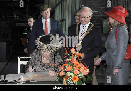 Queen Beatrix of the Netherlands signs the steel book during her visit to the Zeche Zollverein monument and the Ruhr Museum in Essen, Germany, 15 April 2011. Behind her stand Prince Willem-Alexander (behind her), Princess Maxima (covered), Reinhard Pass, first mayor of Essen and North Rhine-Westphalian Prime Minister Hannelore Kraft (r). The Dutch Royal Family visit the German neig Stock Photo
